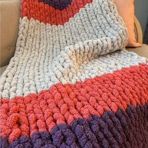 Handmade chunky knit grey, pink and purple baby blanket.